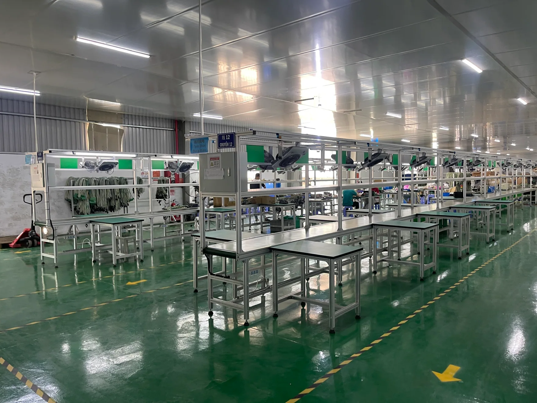 Assembly workstations and cable-handling areas inside the factory.