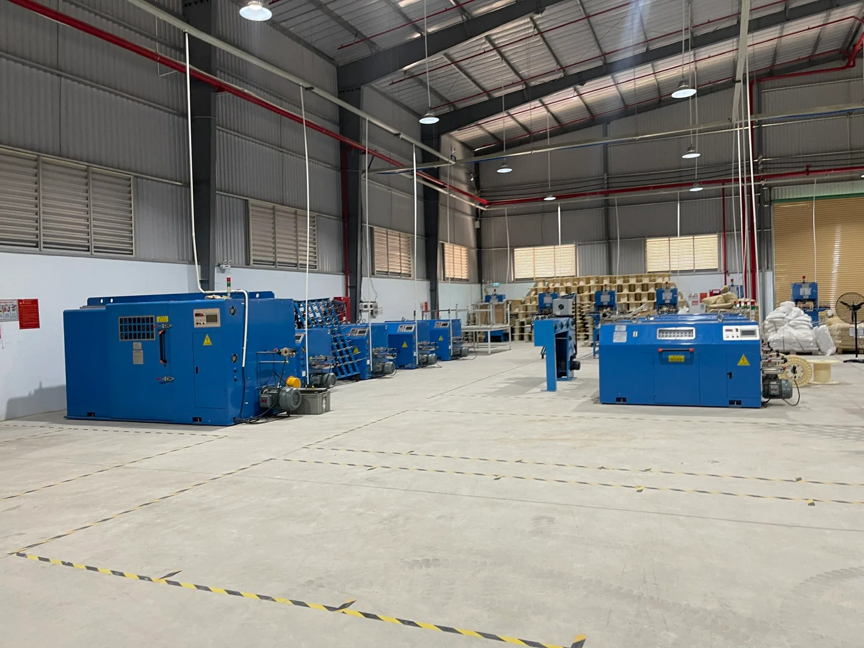 Cable production equipment arranged across the workshop in Vietnam.