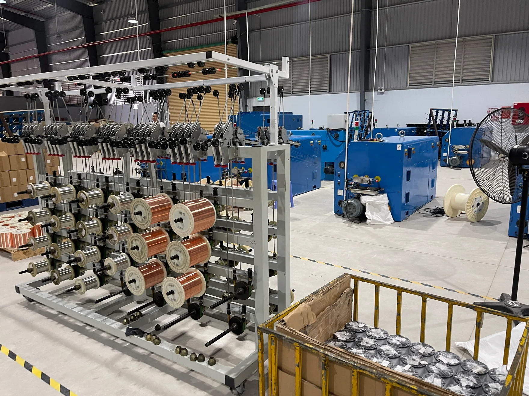 Conductor spools and cable production equipment on the factory floor in Vietnam.
